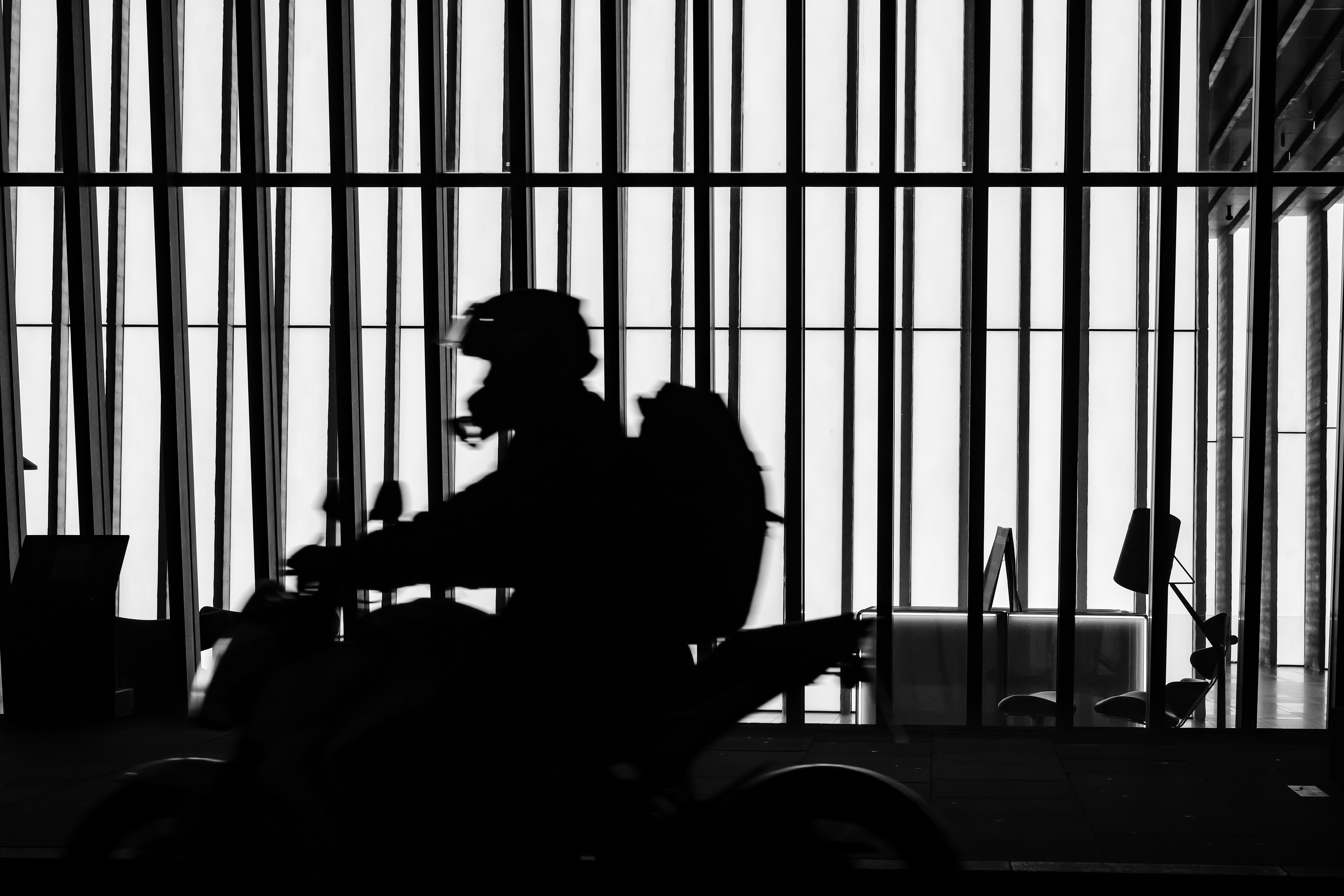 A man riding a motorcycle next to a tall building